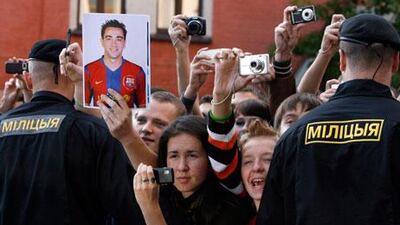 A Barcelona fan holds a portrait of Xavi while others take pictures amid tight security after the team’s arrival in Minsk on Tuesday. Barca, who beat local favourites BATE Borisov on Wednesday, have a huge fan following all over the world for the brand of football they play.