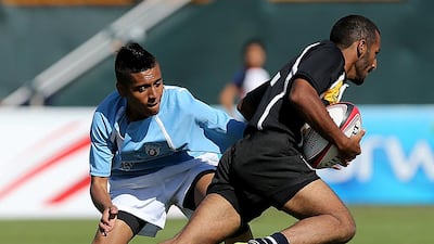Al Ain Mixed Schools, in black, were considered the top contenders to win the schools tournament, but they were upset by the Dubai-based Al Maarif Schools team in the final at the Dubai Sevens ground on Saturday. Satish Kumar / The National