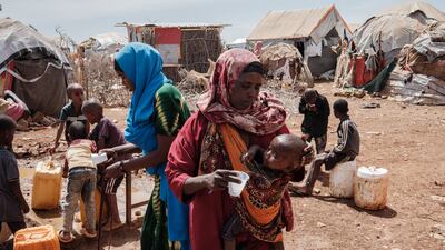 Bulley Hassanow Alliyow,30, gives water to her child at Tawkal 2 Dinsoor camp for internally displaced people in Baidoa.