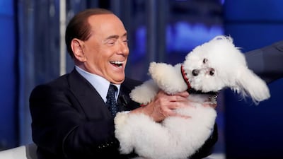 Italy's former Prime Minister Silvio Berlusconi plays with a dog during the television talk show 'Porta a Porta' (Door to Door) in Rome, Italy June 21, 2017. REUTERS