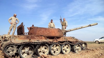 Iraqi soldiers stand on a damaged tank during fighting against ISIL militants near Tikrit, northern Iraq, on February 24, 2015. Ali Mohammed/EPA