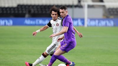Al Ain's Caio Canedo, right, shields the ball from Al Jazira's Omar Abdulrahman.