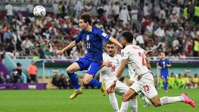 USA midfielder Brenden Aaronson battles for the ball with Iran defenders Majid Hosseini and Ramin Rezaeian. AFP