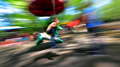 A boy riding a merry-go-round horse at a playground in Bucharest, Romania, May 15. EPA