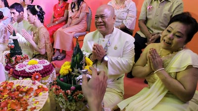 Reungsit Maksornteerachote, a 60-year old Thai groom, and his bride Ananya Ngarmarom, 50, right, get the blessing from a well-wisher during a mass wedding held to celebrate St. Valentine's Day in Bangkok, Thailand, Tuesday, Feb. 14, 2012. (AP Photo/Apic???
