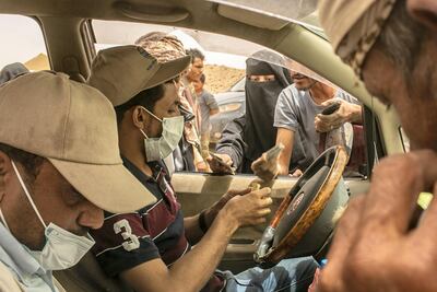 Internally displaced Yemenis gather around a humanitarian aid employee to register their names at a new displacement camp in Marib province. Asmaa Waguih for The National