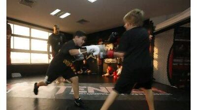 Dubai, United Arab Emirates - September 19, 2012. ( Left to right ) Adam Babb ( 9 years old from USA ) and Fintan Hughes ( 9 years old of USA ) sparring during their routine workout for the Mixed Martial Arts class. ( Jeffrey E Biteng / The National )