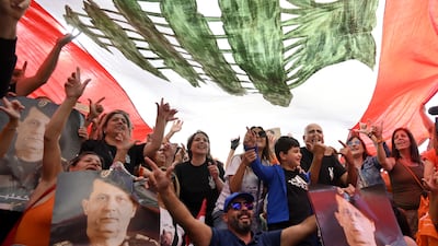 Supporters of the outgoing Lebanese President Michel Aoun pose under a national flag as they gather at Baabda Palace ahead of Aoun's farewell ceremony at the end of his term, Baabda, east of Beirut, Lebanon. EPA