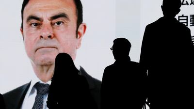 Pedestrians look at a huge screen displaying breaking news about the detention of former Nissan chairman Carlos Ghosn in Tokyo, Japan. EPA