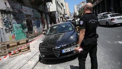 A police officer stands on a street next to a damaged car following an earthquake in Athens, Greece, July 19, 2019. REUTERS/Alkis Konstantinidis