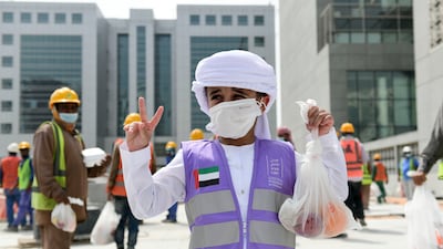 Mubarak Saeed Al Mazrouei, 5, young Emirati volunteer hands out food and snacks to construction workers, which is part of the initiative by the Supreme Council of Motherhood and Childhood, in Abu Dhabi. Khushnum Bhandari / The National