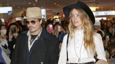 File photo of US actor Johnny Depp and his wife, model-actress Amber Heard. Heard was charged on Tuesday with two counts of illegally importing the couple's terrier, Pistol and Boo, into Australia. Shizuo Kambayashi/AP Photo