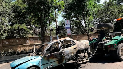 A damaged car is towed away from the site. AP Photo