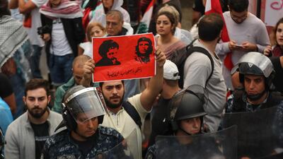 A protester holds a poster bearing the portraits of the founder of the Amal movement Imam Mussa al-Sadr, right, and Argentine-born revolutionary leader Ernesto 'Che' Guevara reading in Arabic "You are the cause leaders" at Riad al-Solh square in Beirut. AFP