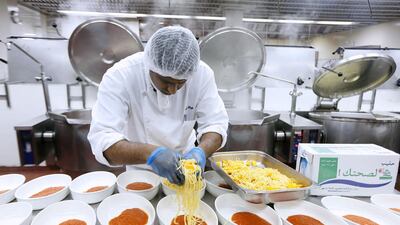 A cook prepares food inside the kitchen at Dubai World Trade Centre in Dubai. Pawan Singh / The National