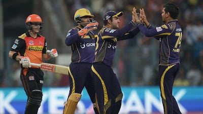 Kolkata Knight Riders bowler Sunil Narine, right, celebrates with teammates including captain Gautam Gambhir, second right, after the dismissal of Sunrisers Hyderabad captain David Warner, left. AFP / Dibyangshu SARKAR