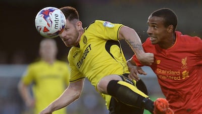 Burton Albion midfielder Calum Butcher holds off Liverpool defender Joel Matip to head the ball. Oli Scarff / AFP