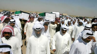 Relatives of Kuwaiti prisoners of war Nasser Al Onezi, Anam Al Aidan and Abdullatif Al Wahib, whose remains were found in a mass grave in southern Iraq, carry their coffins to the cemetery in Kuwait City on July 9, 2003. AFP