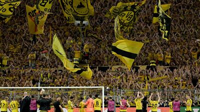 Dortmund's Yellow Wall applauds the players after the victory over PSG. PA