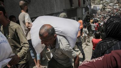 A man carries a sack of flour from a World Food Programme distribution point in Gaza city on July 26. Bloomberg