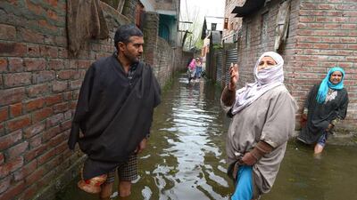 Kashmiri residents wade through floodwaters outside their homes as water levels rise nearby in Dal Lake in Srinagar on April 1, 2015. Tauseef Mustafa/AFP Photo