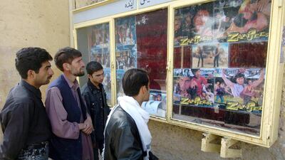 Men look at film posters outside the Cinema Park in 2005. AFP