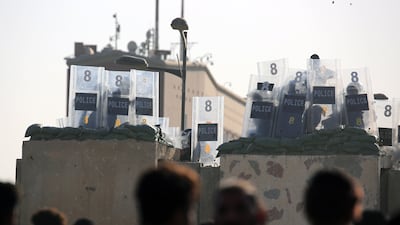 Iraqi anti-riot forces take cover during clashes with protesters trying to storm the government area of the green zone in Baghdad, on October 1. EPA
