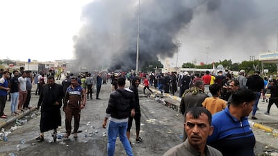 Iraqi protesters gather as smoke rises from a burning military truck after clashes between protesters and Iraqi policemen in Nasiriyah city, some 370km southeast of Baghdad, Iraq. EPA