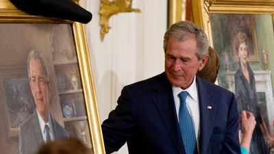 Mr Bush and the former first lady unveil their portraits in the East Room of the White House, in 2012. AP