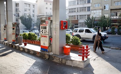 An Iranian woman walks next to a petrol station in Tehran, Iran, October 26. Petrol stations across Iran were out of service and could not sell fuel after the system handling fuel subsidies sales was disrupted in what official sources said was due to a cyberattack. EPA