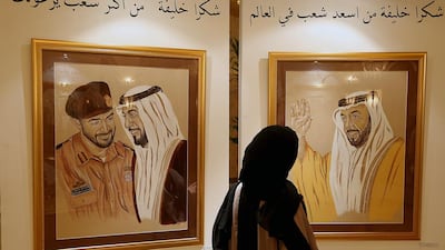 Emirati artist Lateefa Mohammed examines some of her works at Emirates Palace in Abu Dhabi. Satish Kumar / The National