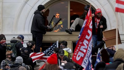 Supporters of then-US president Donald Trump climb through a window during the Capitol riot in Washington on January 6, 2021. Reuters