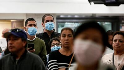 Passengers wearing masks wait at Benito Juarez international airport in Mexico City on January 24. Airlines and airports across the globe are taking precautions following the coronavirus outbreak in China. Carlos Jasso / Reuters