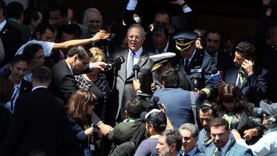 Peru's President Pedro Pablo Kuczynski is surrounded by the press as he waits for his car. Luis Hidalgo / AP
