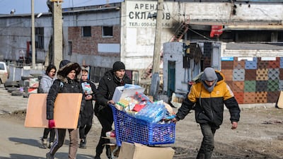 Residents carry water from a food warehouse, which is under the control of the breakaway Donetsk People's Republic, on the outskirts of Mariupol. AP