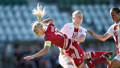 Polands Agata Gusciora, centre, tackles Denmark’s Pernille Harder, front, during the Women’s European Championship qualifying soccer match between Denmark and Poland in Viborg, Denmark. Scanpix Denmark / Henning Bagger / via Reuters