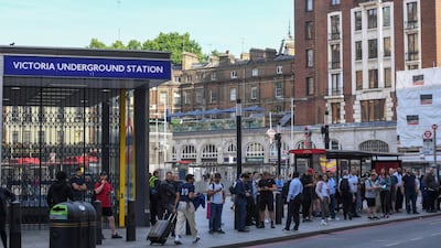 Commuters wait at a bus stop outside a closed Victoria station. Bloomberg