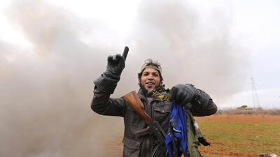 Rebel fighter holds parts of the uniform of the pilot from the Syrian government helicopter that was shot down in Idlib province. AP