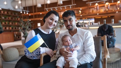 A family carry the Ukraine flag at an Independence Day celebration in Al Qana, Abu Dhabi