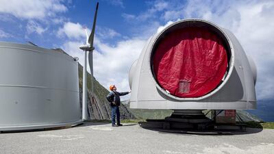 A worker stands next to part of a wind turbine at Griessee lake. Olivier Maire / EPA