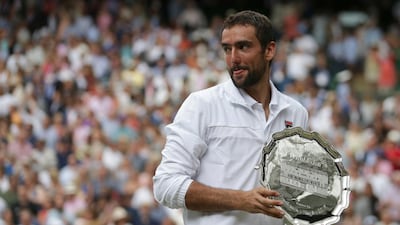 Marin Cilic holds the runners-up trophy after losing to Roger Federer in the Wimbledon final on Sunday. Daniel Leal-Olivas / AP Photo