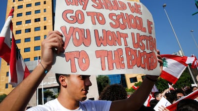 A student protester holds a placard as he protests against the government in front of the education ministry in Beirut. AP Photo