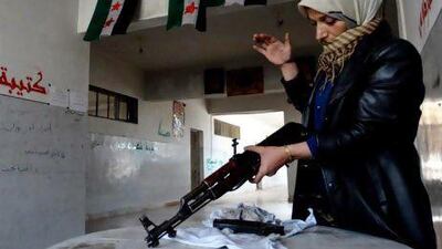 The mother of a Syrian rebel cleans a rifle in Aleppo.