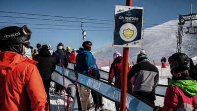 People wear protective face masks while queuing for ski lifts in France. AFP