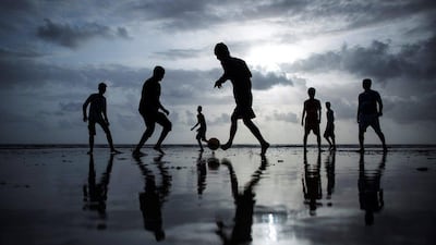 People are silhouetted as they play football at a beach along the Arabian Sea in Mumbai, India, on June 25, 2014. Danish Siddiqui / Reuters