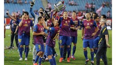 Barcelona's Pedro Rodriguez, center, holds up the trophy to celebrate the team's victory in the Copa del Rey final against Athletic Bilbao on Friday night. Andres Kudacki / AP Photo