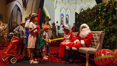 Santa Claus and Mrs Claus hand out gifts at a Christmas lunch in Sydney, Australia. EPA