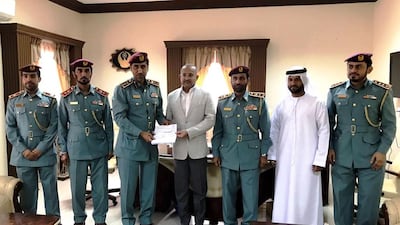 Senior officers and dignitaries from Ajman Police recognise Firoz Merchant, centre, for his generosity. Courtesy Pure Gold Jewellers