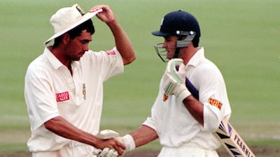 Hansie Cronje congratulates Graeme Hick at the end of play after the England batsman had reached his century in the first Test at Pretoria in 1995. PA