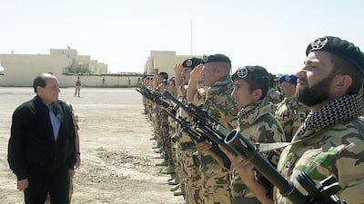 Italian Prime Minister Silvio Berlusconi reviews a detachment of Italian soldiers in Nasiriyah, Iraq, in April 2004 during a surprise visit to Italian troops. AFP